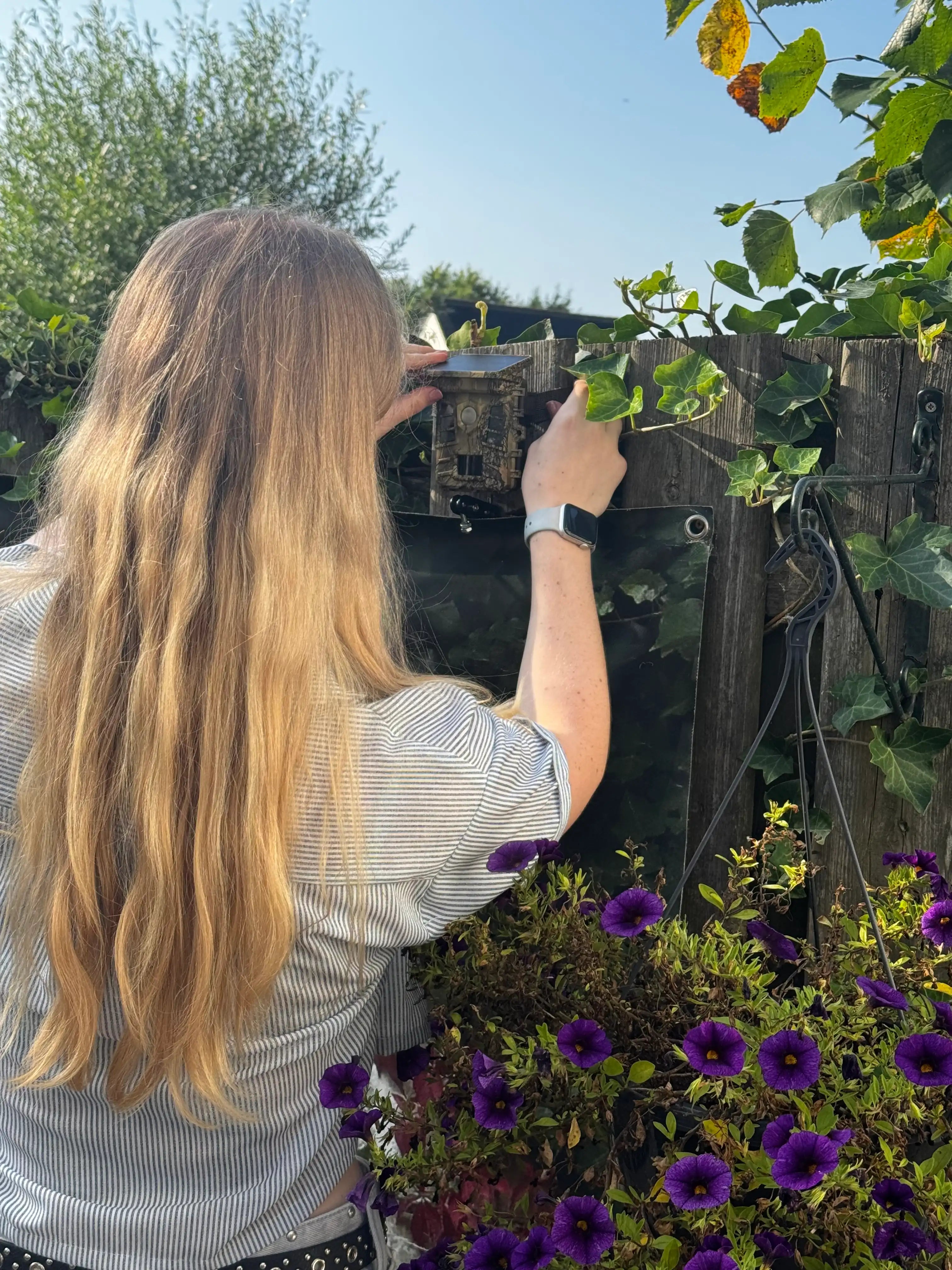 Vrouw die de camtura wildcamera met wifi en zonnepaneel gebruikt